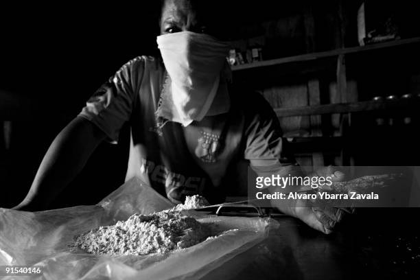 Local narcotics trafficker displaying pure cocaine. All the different armed groups who take part in the conflict within Colombia benefit financially...