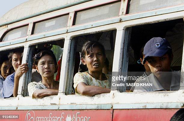 Residents ride a bus on the outskirts of Yangon, 12 December 2004. Myanmar's economy is suffering from years of mismanagement, sanctions and a recent...