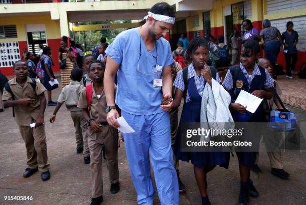 Ten year old girl named Jada grabs onto Michael Golub's hand as he was passing through the courtyard at Brown's Town Primary School in Brown's Town,...