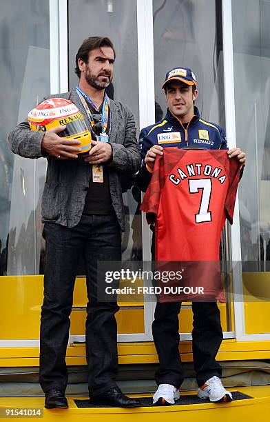 Renault's Spanish driver Fernando Alonso and French former football player and actor Eric Cantona pose during a photocall at the Silverstone circuit...