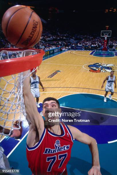 Gheorghe Muresan of the Washington Bullets dunks during a game played on March 13, 1995 at the Charlotte Coliseum in Charlotte, North Carolina. NOTE...