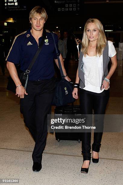 Shane Watson and his partner Lee Furlong walk through the airport terminal during a press conference upon their return to Australia at Sydney...