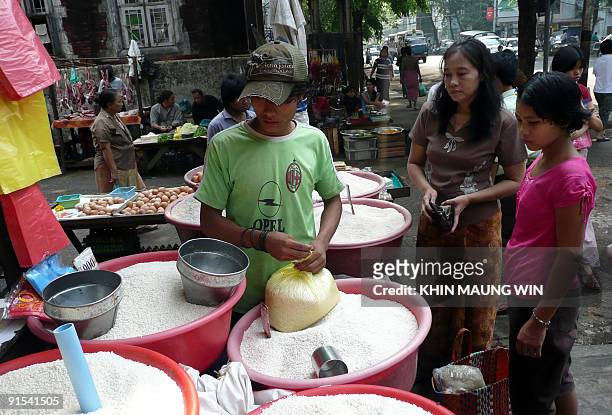 Vendor packs rice for a customer at his roadside shop in Myanmar's biggest city Yangon on March 14, 2008. Myanmar is under US and European sanctions,...