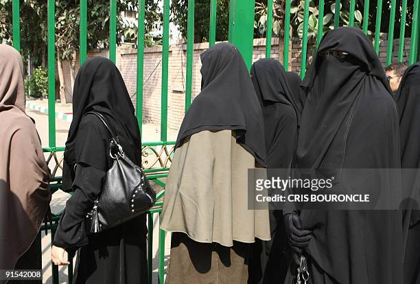 Cairo University students wearing the niqab, a black veil which covers the face except for the eyes, stand outside the university dormitory on...