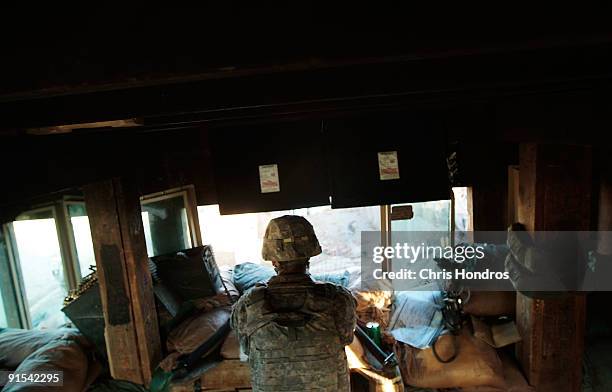 Army Spc. Randall Smith of Mocksville, North Carolina with 3/509th of the 25th Infantry Division keeps watch in a guard tower at Forward Operating...