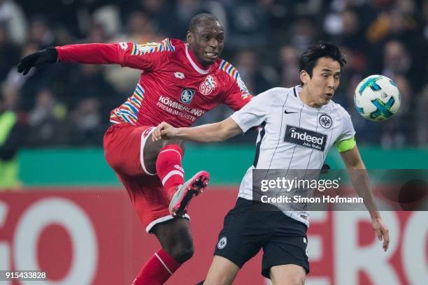 Anthony Ujah of Mainz is challenged by Makoto Hasebe of Frankfurt during the DFB Cup quarter final match between Eintracht Frankfurt and 1. FSV Mainz...