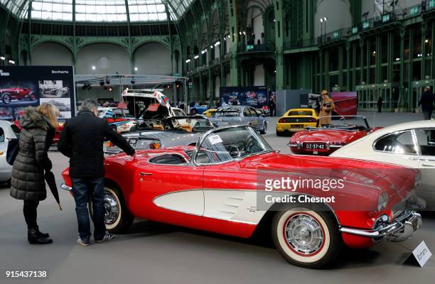 Couple look at a Chevrolet Corvette Roadster 1961 displayed during a press preview before a mass auction of vintage vehicles organised by Bonhams...