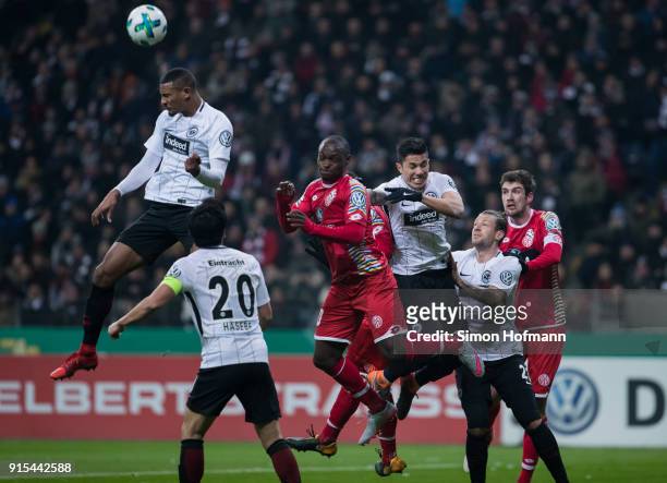 Sebastien Haller of Frankfurt jumps for a header in front of Anthony Ujah of Mainz during the DFB Cup quarter final match between Eintracht Frankfurt...