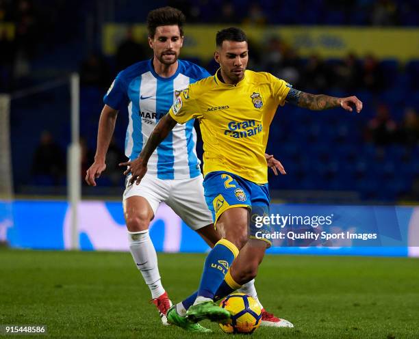 Jonathan Viera of Las Palmas competes for the ball with Adrian Gonzalez of Malaga during the La Liga match between Las Palmas and Malaga at Estadio...