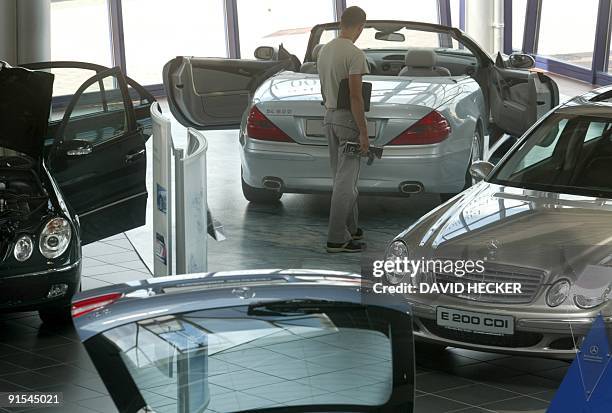 Customer examines a Mercedes-Benz limousine on June 27, 2003 at Mercedes-Benz store Dresden. AFP PHOTO/DDP-Robert Michael