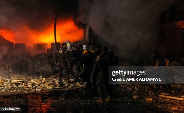 Picture taken on February 7, 2018 shows Syrian civil defence volunteers attempting to put out a fire in the city of Maaret al-Numan in the rebel-held...