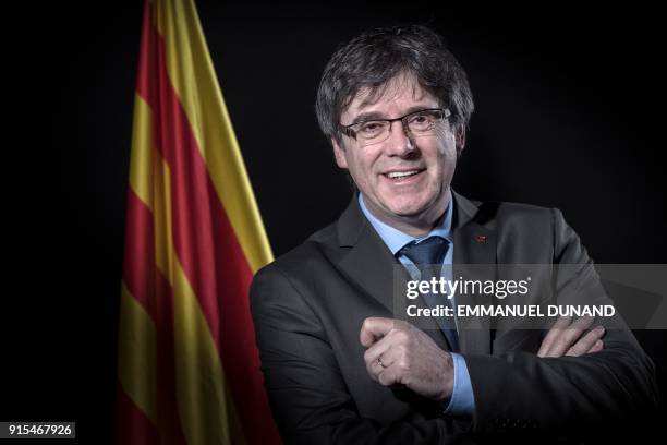 Exiled former Catalan leader Carles Puigdemont poses in front of a Catalan flag during a photo session in Brussels on February 7, 2018.