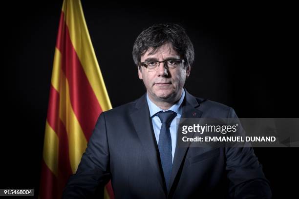 Exiled former Catalan leader Carles Puigdemont poses in front of a Catalan flag during a photo session in Brussels on February 7, 2018.