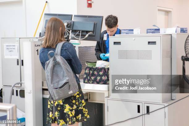female airline passenger  having bag searched by tsa - film and television screening stock pictures, royalty-free photos & images