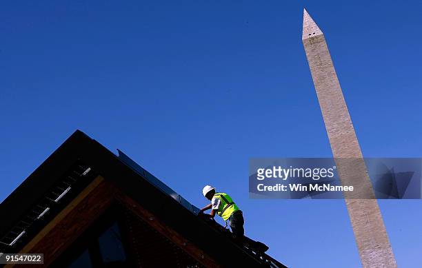 Workers complete final preparations on a home designed by a team from the University of Minnesota on the National Mall at The Energy Department's...