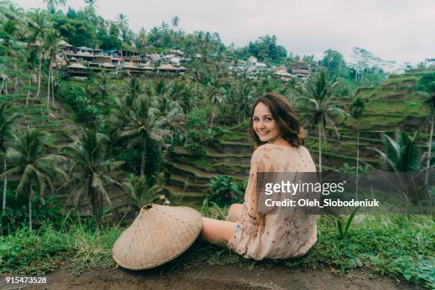 woman sitting with view  on tegallalang rice field in bali, indonesia - asian style conical hat stock pictures, royalty-free photos & images
