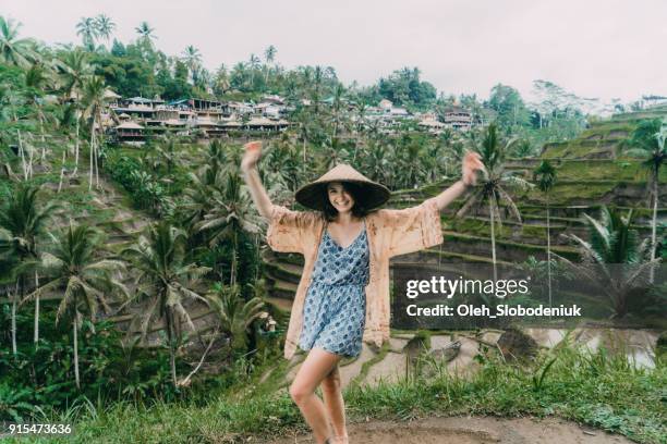 mujer divertirse en tegallalang campo de arroz en bali, indonesia en sombrero cónico de estilo asiático - asian style conical hat fotografías e imágenes de stock