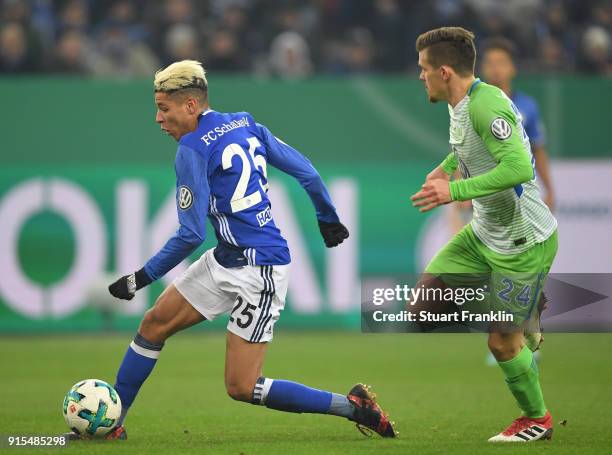 Sebastian Jung of Wolfsburg is challenged by Amine Harit of Schalke during the DFB Pokal quarter final match between FC Schalke 04 and VfL Wolfsburg...