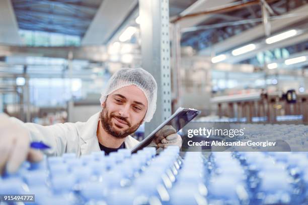 scientist controller doing revision in bottling plant - bottling plant stock pictures, royalty-free photos & images