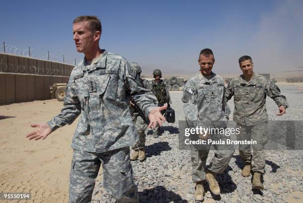 Commander General Stanley A. McChrystal arrives from a helicopter with his staff at a small military outpost for a meeting with high ranking military...