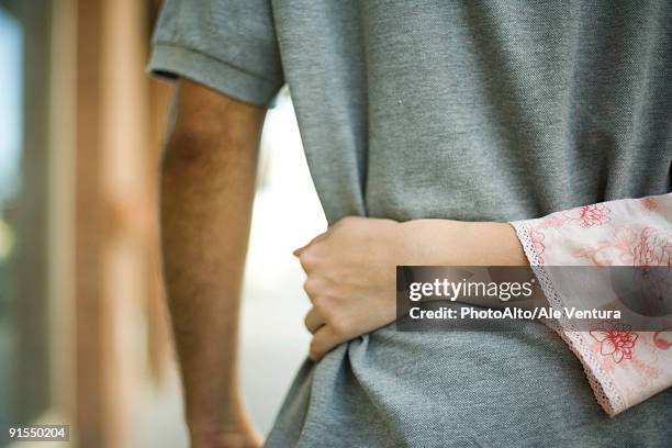 woman's arm around man's waist, rear view - hugging mid section stock pictures, royalty-free photos & images