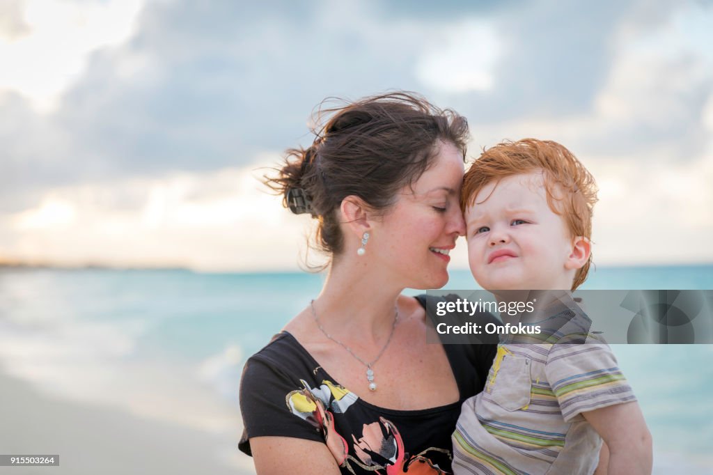 Mother Holding Baby Boy at Beach Sunset