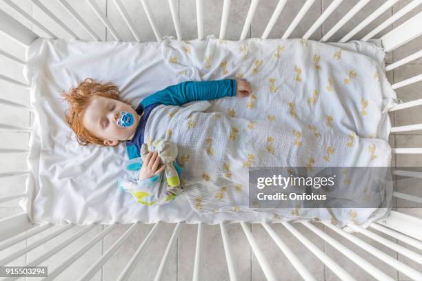 cute redhead baby boy sleeping in the crib - two boys in bed stock pictures, royalty-free photos & images