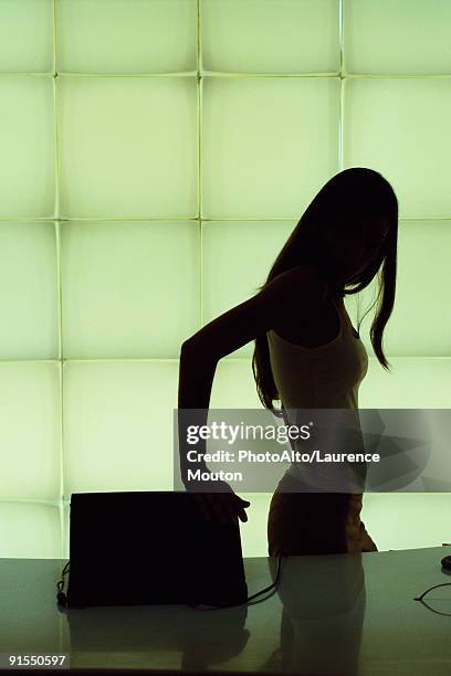 silhouette of woman closing laptop computer - closing laptop stock pictures, royalty-free photos & images