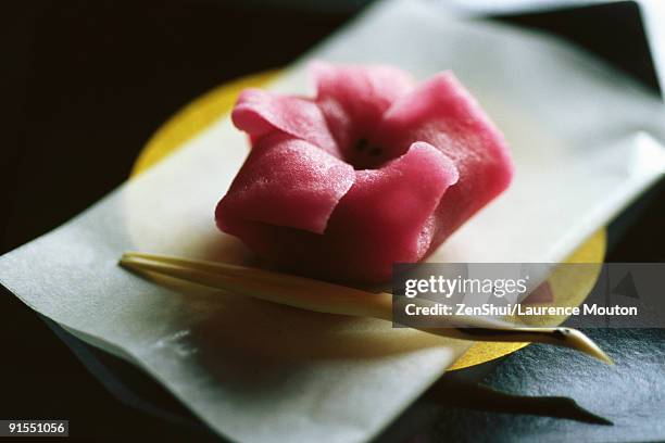 single pink wagashi on plate - wagashi stockfoto's en -beelden