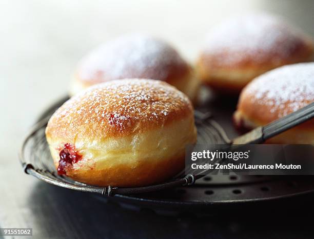 jam filled donut dusted with powdered sugar - donut stock pictures, royalty-free photos & images