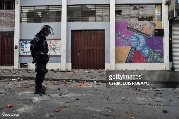 Colombian riot police officer stands in front of the building where Rodrigo Londono Echeverri, known as "Timochenko", the presidential candidate for...