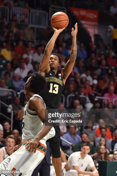 Bryant Crawford of the Wake Forest Demon Deacons shoots a jump shot while being defended by Ebuka Izundu of the Miami Hurricanes during the first...