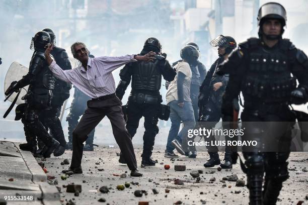 Demonstrator throws stones during a protest against a campaign rally held for Rodrigo Londono Echeverri, known as "Timochenko", the presidential...