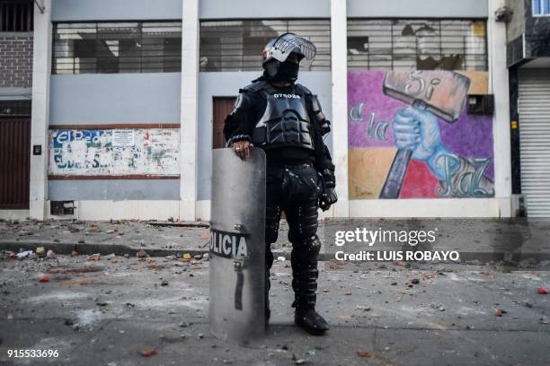 Colombian riot police officer stands in front of the building where Rodrigo Londono Echeverri, known as "Timochenko", the presidential candidate for...