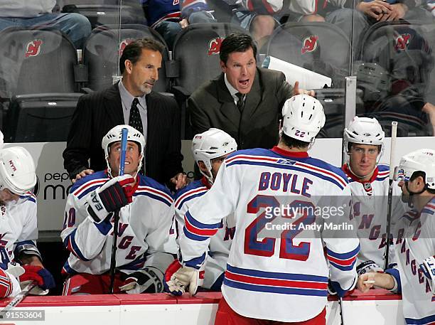 Head Coach John Tortorella of the New York Rangers looks on during a timeout as Assistant Coach Mike Sullivan gives instructions against the New...