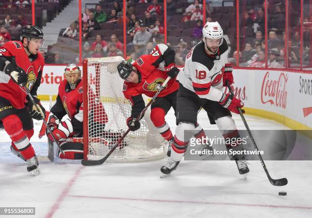 New Jersey Devils Right Wing Drew Stafford stickhandles the puck behind the Senators goal as Ottawa Senators Dion Phaneuf , Goalie Craig Anderson and...