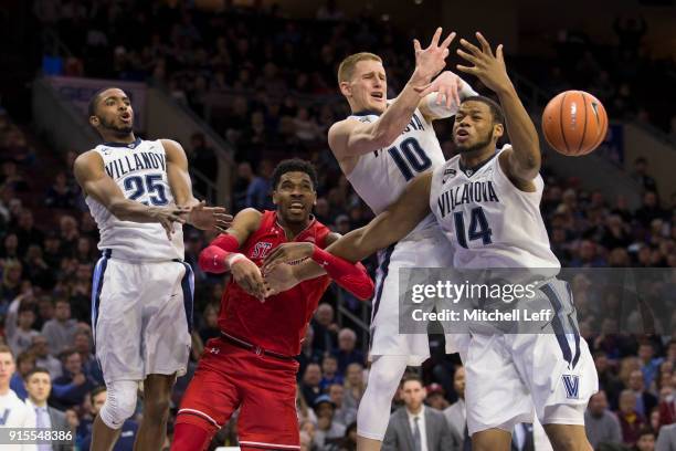 Mikal Bridges, Donte DiVincenzo, and Omari Spellman of the Villanova Wildcats reach for the ball along with Justin Simon of the St. John's Red Storm...