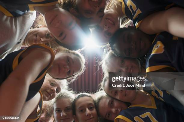 female basketball players and coach huddling together in circle - children sport foto e immagini stock