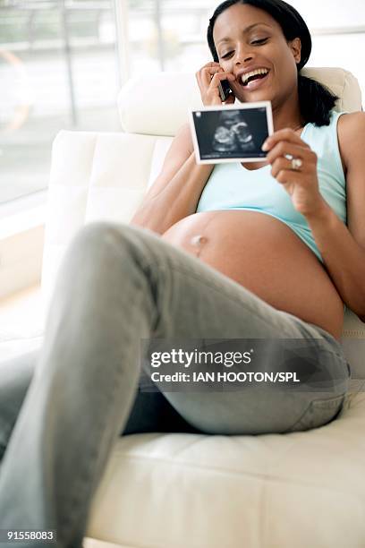 pregnant woman holding ultrasound scan of unborn child - ultra sonography stock pictures, royalty-free photos & images