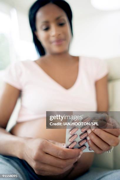 pregnant woman holding tablets containing folic acid - vitamin sachet stock pictures, royalty-free photos & images