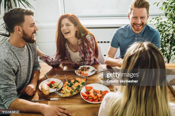 amigos alegres comunicarse mientras disfruta de una comida en mesa de comedor. - double date fotografías e imágenes de stock