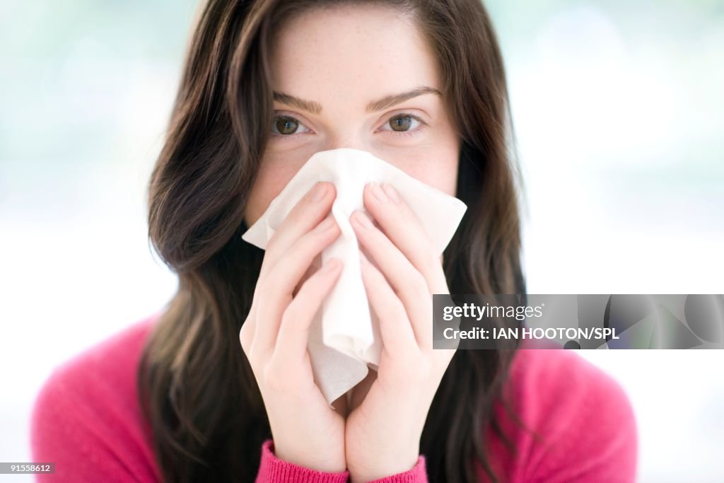 Woman blowing nose with handkerchief