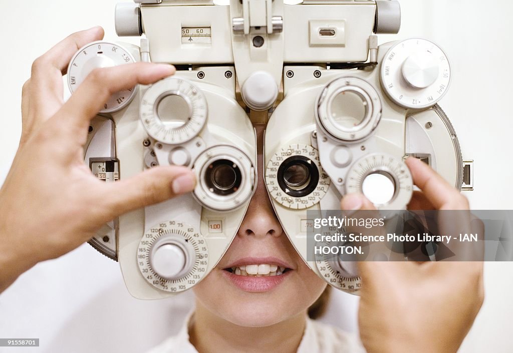 Optometrist (optician) examining eye of woman