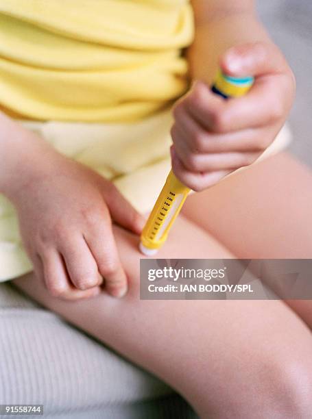 girl (4-5) with condition diabetes mellitus injecting with insulin using anovopen - thigh stock photos et images de collection