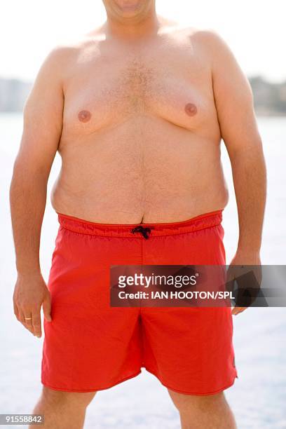 overweight man wearing swimming trunks - fat guy on beach fotografías e imágenes de stock
