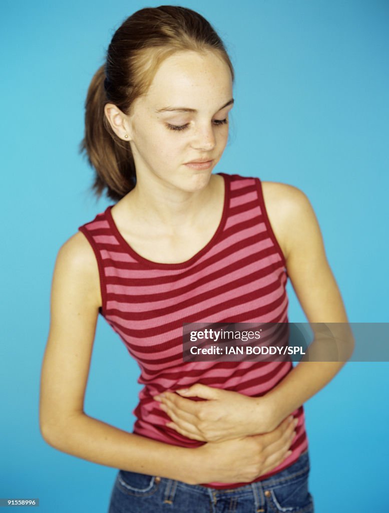 Girl (13-14) holding stomach in pain