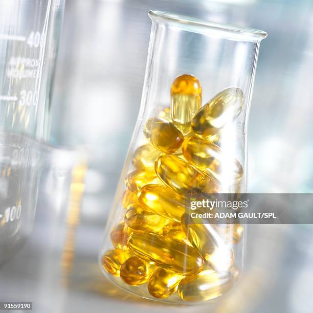 cod liver oil capsules in conical flask - fish oil foto e immagini stock