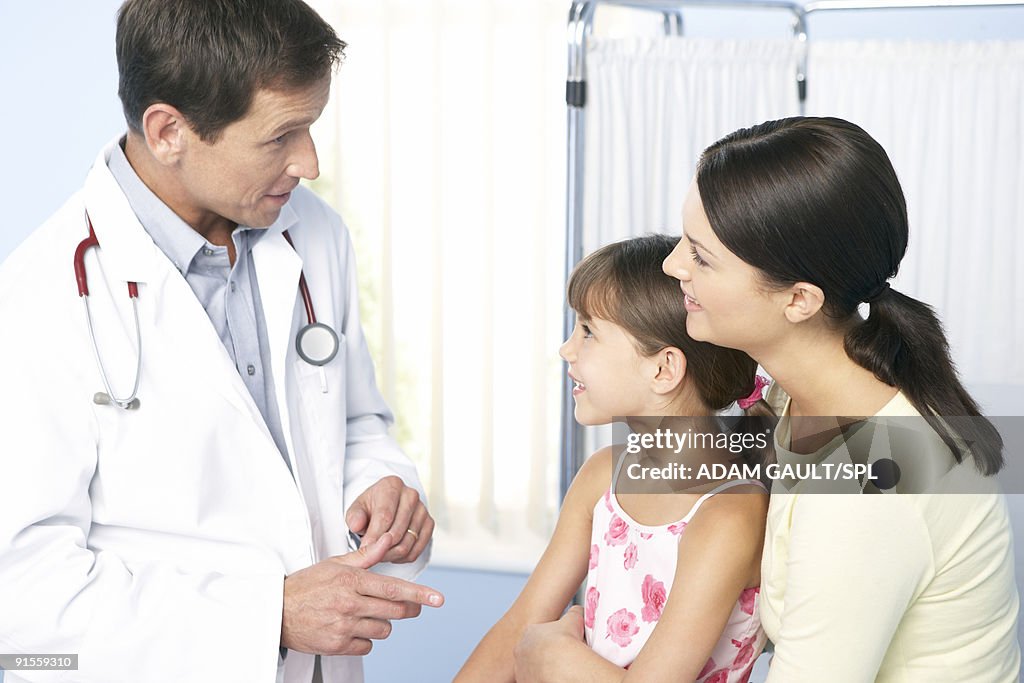 Mother holding daughter while talking to daughter