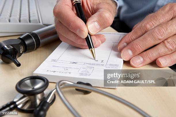 general practice doctor writing prescription - prescription imagens e fotografias de stock