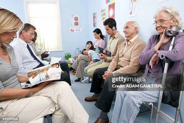 general practice waiting room filled with patients - waiting room fotografías e imágenes de stock